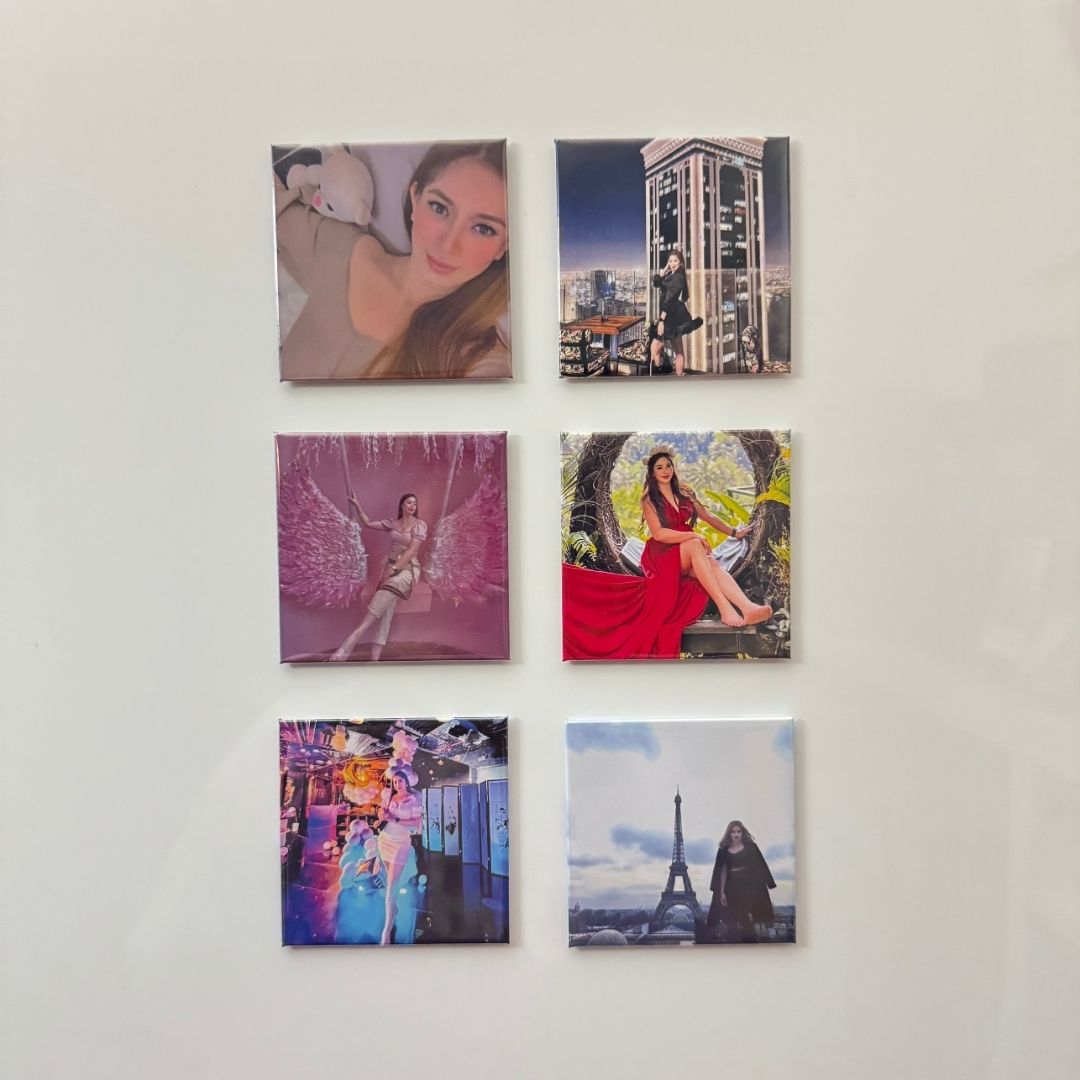 Six square cusrom photo magnet feature portraits, cityscapes, and artistic scenes, arranged neatly on a white surface.